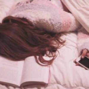 ベッドでスマホを持つ女性